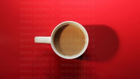 عکس استوک فنجان قهوه از نمای بالا با پس زمینه قرمز